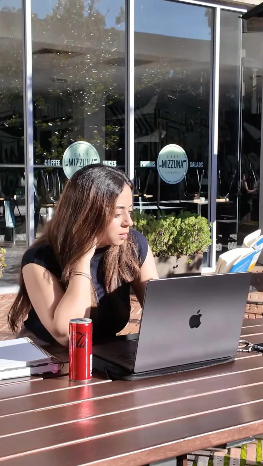 Priyanka working on her laptop outside a cafe