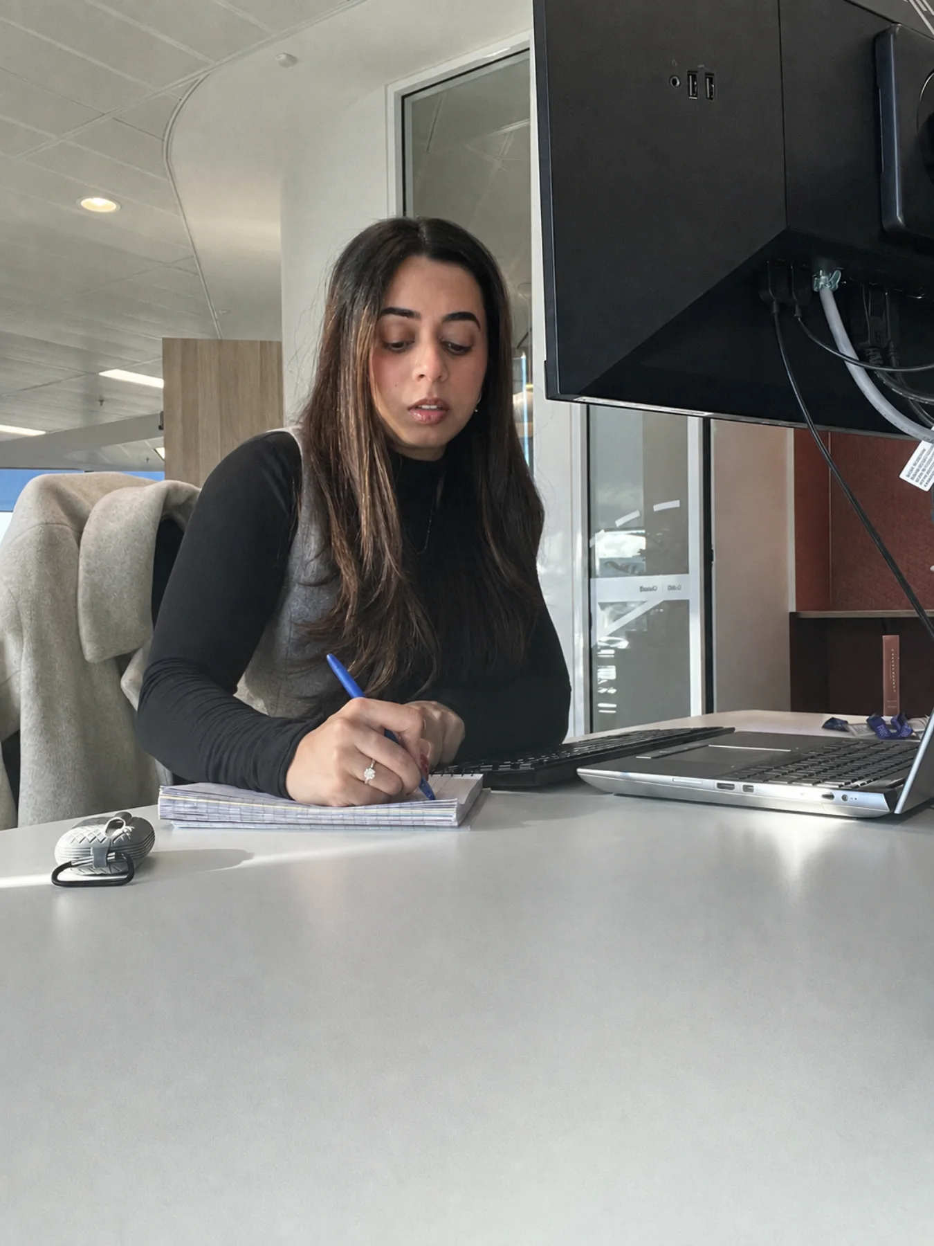 Priyanka writing notes at her office desk